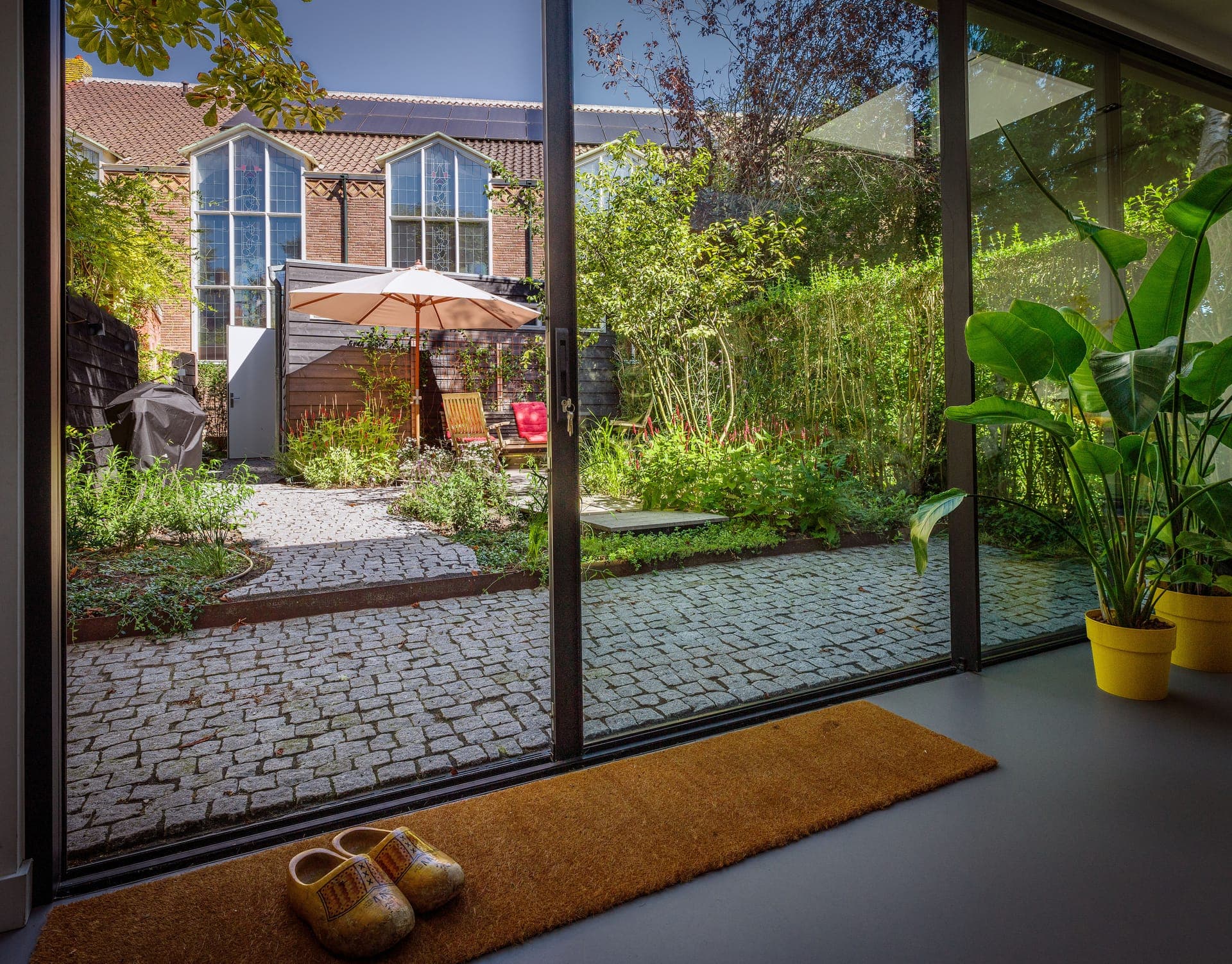 Doorkijk vanuit de woning naar de binnentuin met kinderkopjes