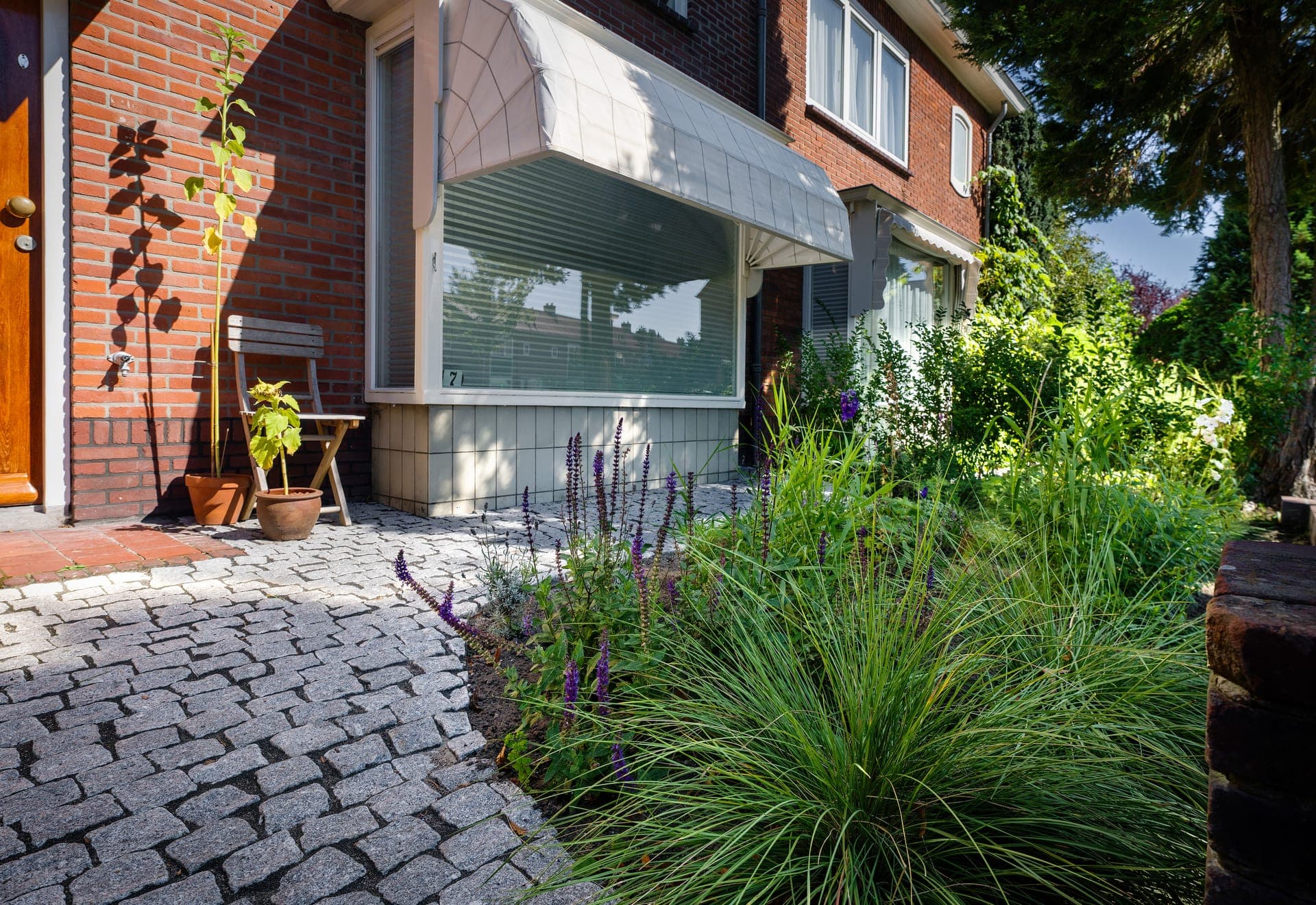 Voortuin met gebakken klinkers, siergrassen en lavendel