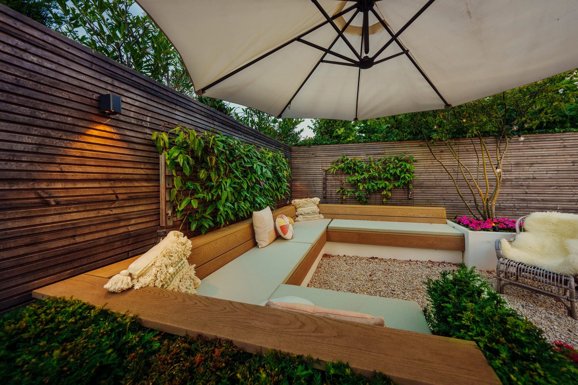 Verdiepte loungebank in houten omkadering met parasol