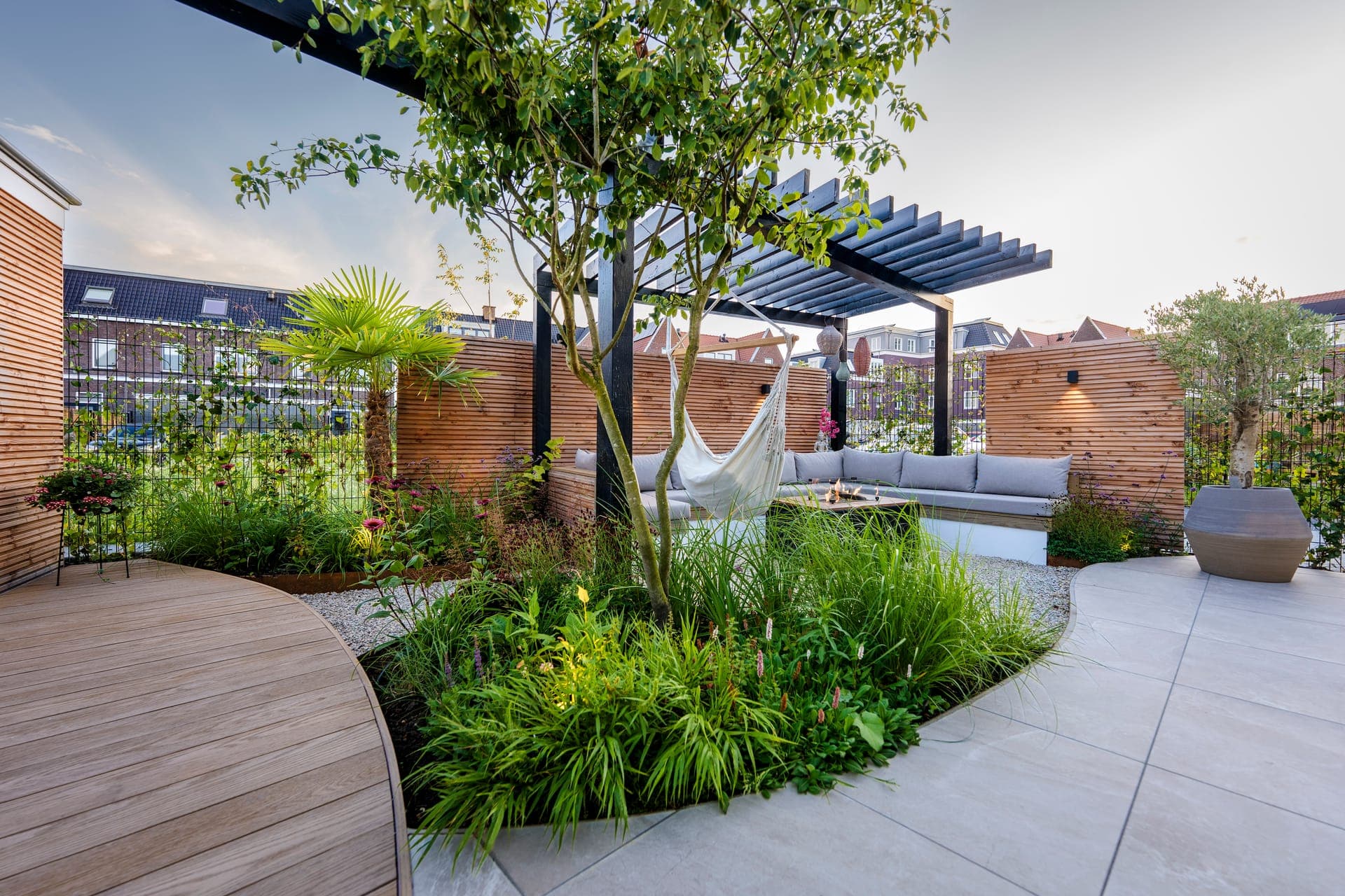 Pergola met hangmat omringd door groene borders