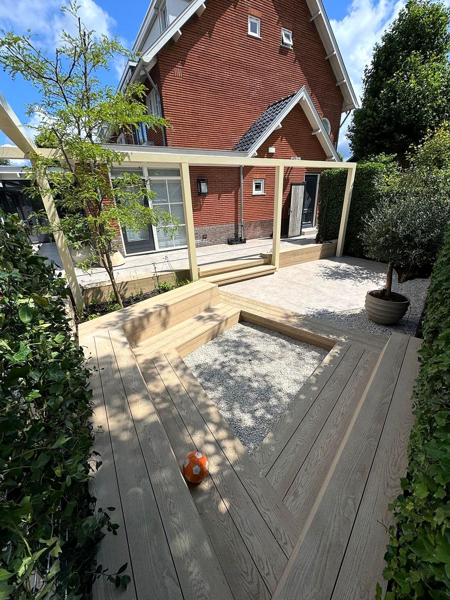 Pergola met plantenbak en zitrand op het terras