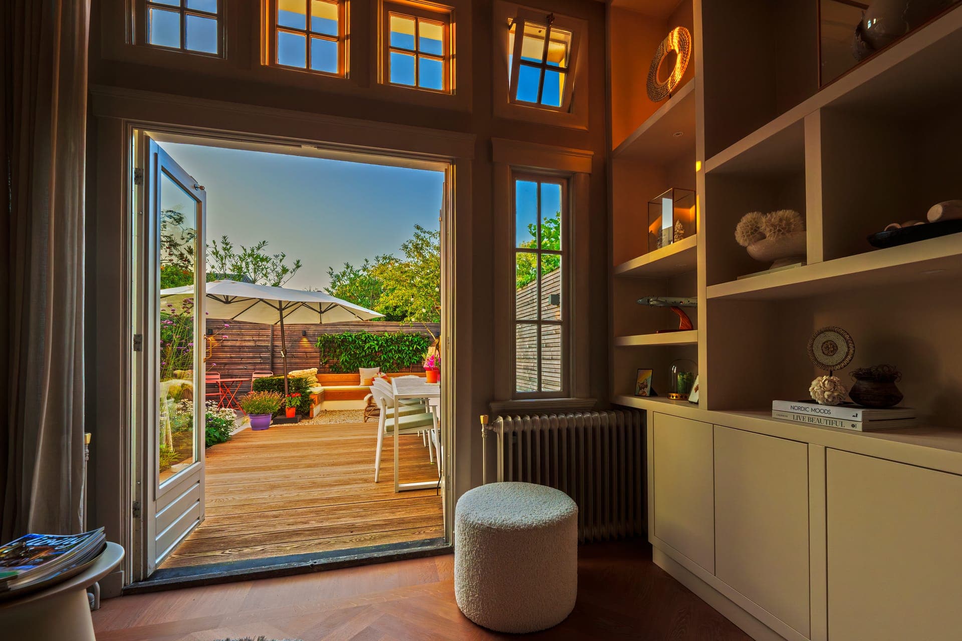 Doorkijk vanuit de woning naar het verlichte terras
