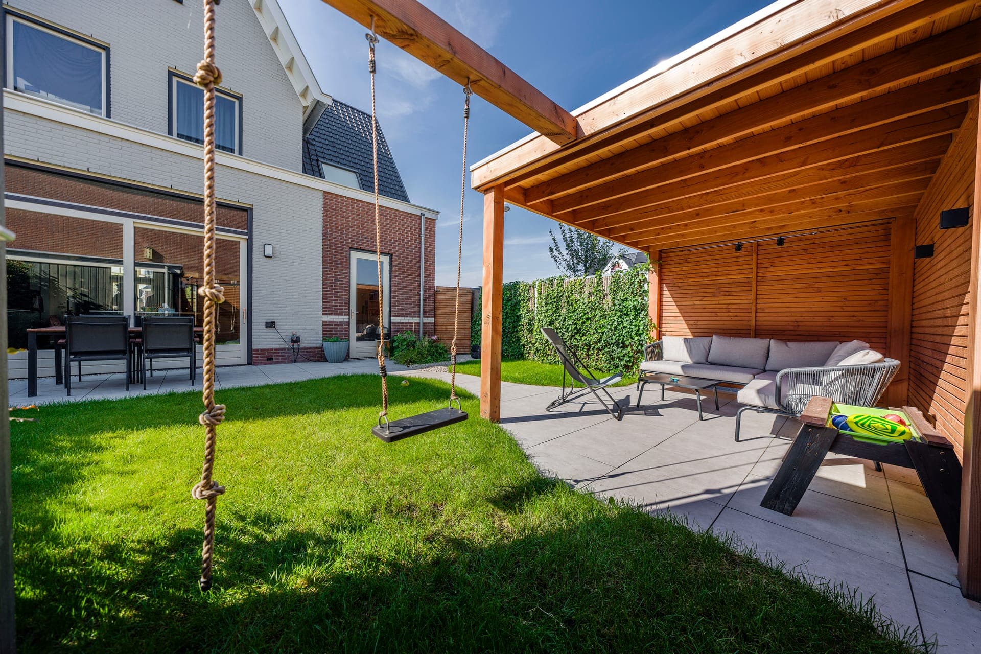 Houten pergola met touwschommel en klimtouw