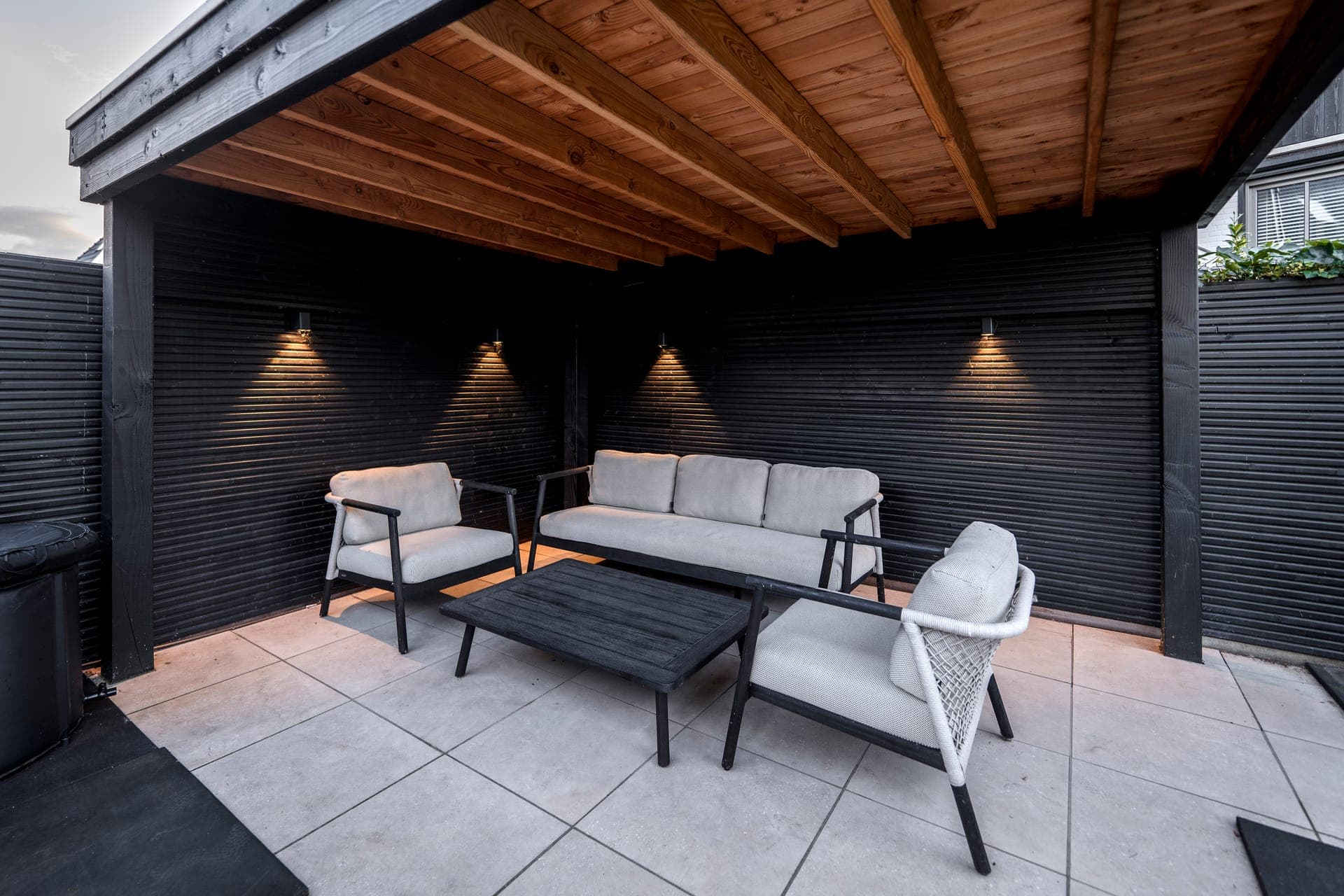 Overdekte lounge met houten plafond, een voorbeeld van onze overkappingen